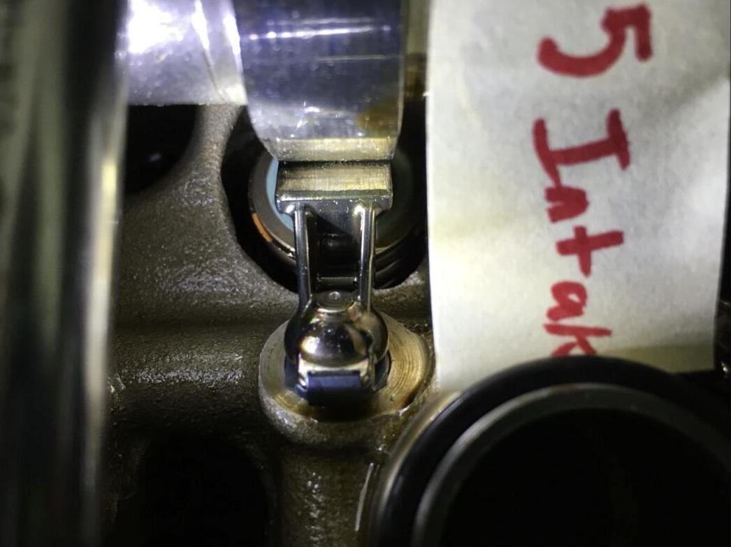 Close-up of a finger follower in the head during inspection, labeled cylinder 5 intake