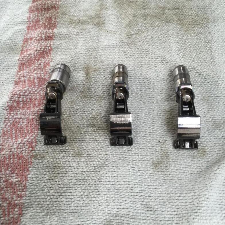 Three removed finger followers on a shop towel showing wear stripes across the contact pads